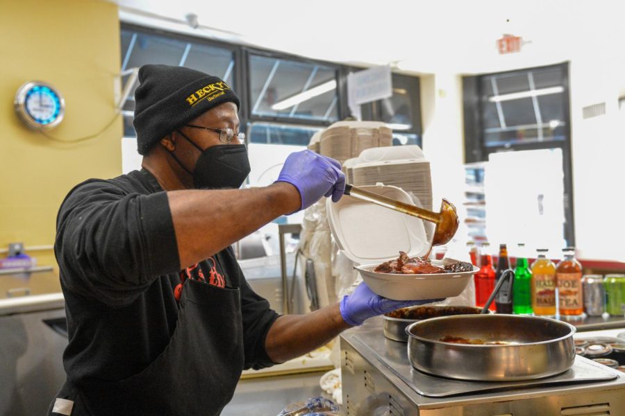 Johnson ladles sauce onto an order of rib tips. The restaurant barbecues meat every morning. 
