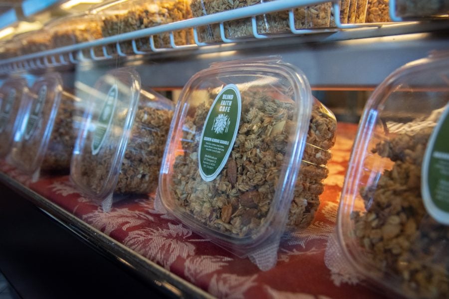 Packaged granola with green labels rests on a shelf in Blind Faith Cafe.