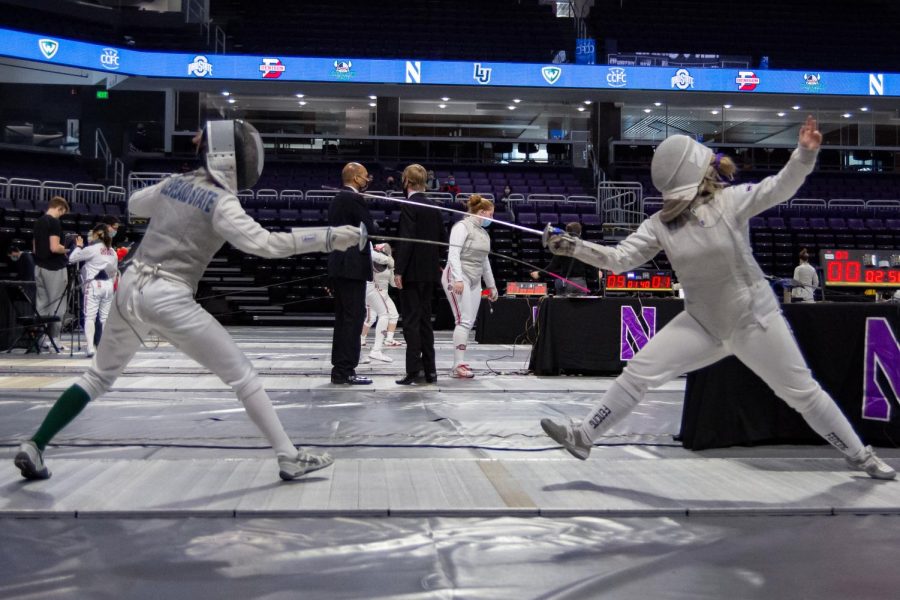 Two fencers look at each other in position, about to attack.