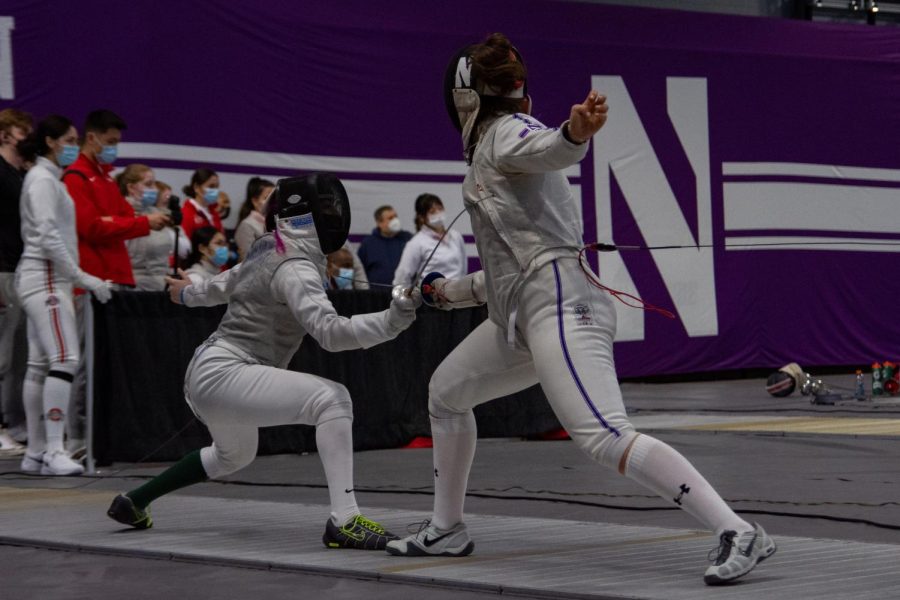 The fencer on the left crouches down and points their weapon up towards their opponent.
