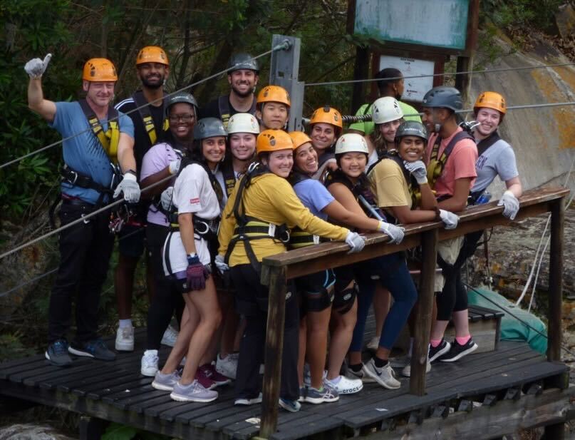 Students pose for a picture on a zip lining platform.