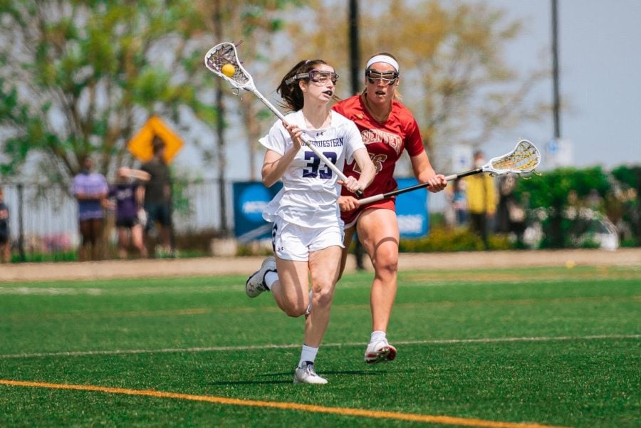 A lacrosse player wearing white holds her stick and runs