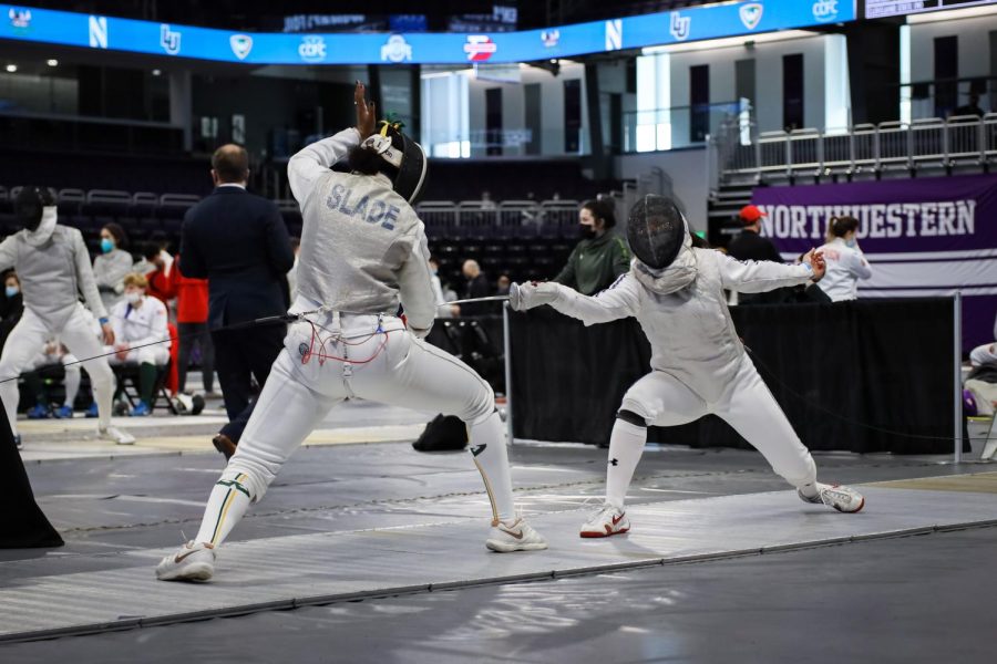 The fencer on the right points their weapon towards their opponent.