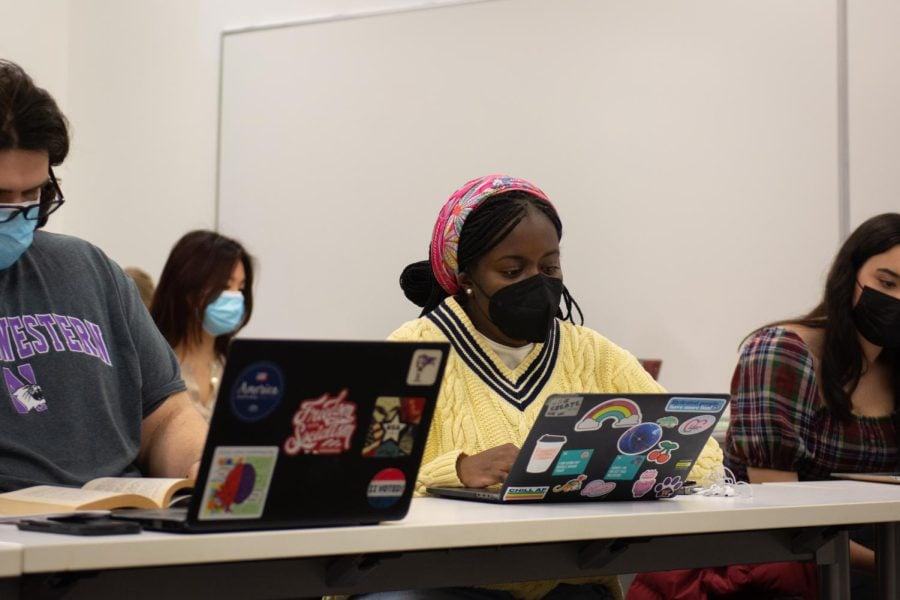 Masked ASG members sit in a meeting with laptops open