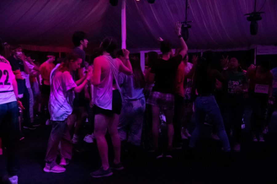 A crowd of students dance in a tent.