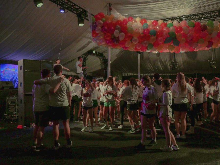 A crowd of students dances in a tent.