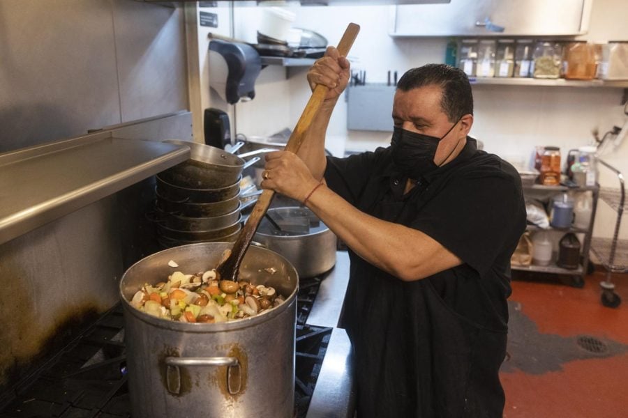 A chef at Prairie Moon restaurant stirs a pot filled with soup.