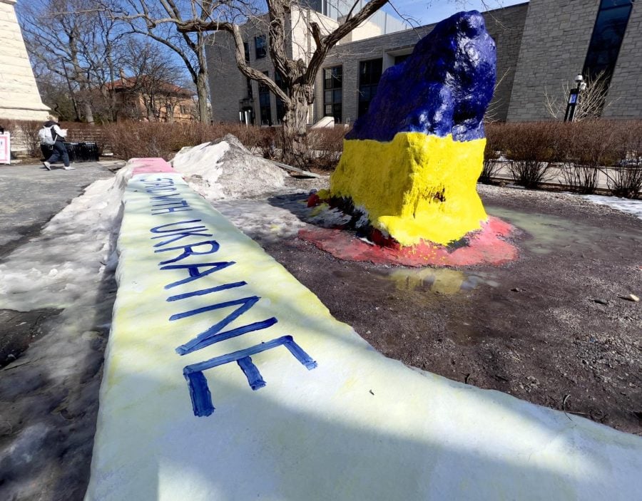 Northwestern’s Rock from the side painted blue and yellow. Painted blue message on the wall in front saying Ukraine.