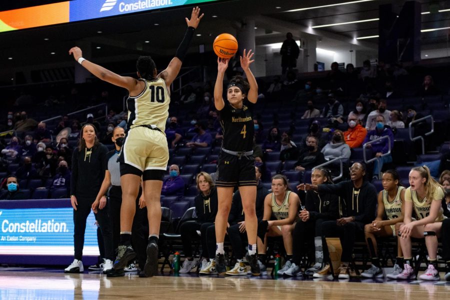 Girl in black uniform shoots basketball