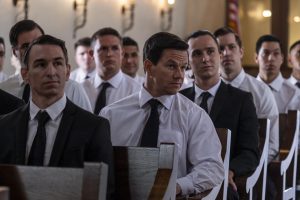 Stuart Long (Mark Wahlberg) sits in a church, surrounded by other seminarians in suits and ties.