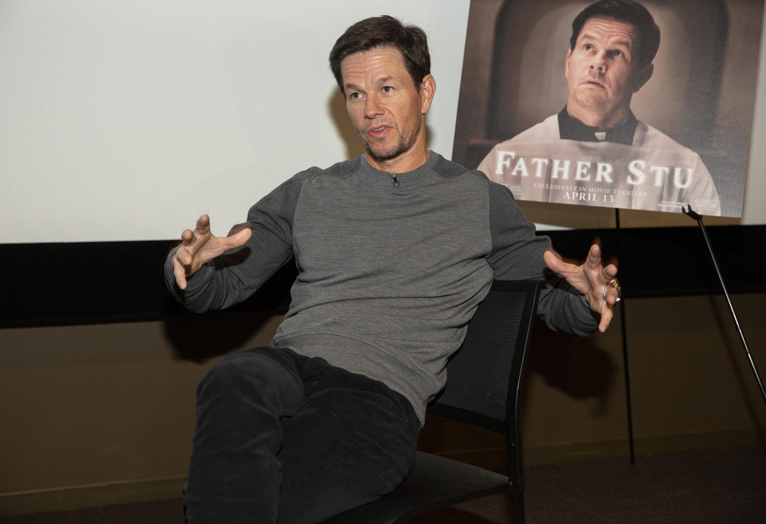 Mark+Wahlberg+sits+in+front+of+a+poster+for+his+new+film%2C+%E2%80%9CFather+Stu.%E2%80%9D