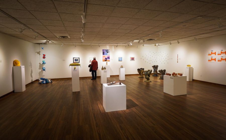 The photo showcases Dittmar Gallery’s new exhibit “Wordless Creatures”. Most of the work for the exhibit is included in the photo, including Matthew Cortez’s “A Weak Connection to the Former Self” on the left side of the image and Madison Gondreau’s “Reflections” on the right.