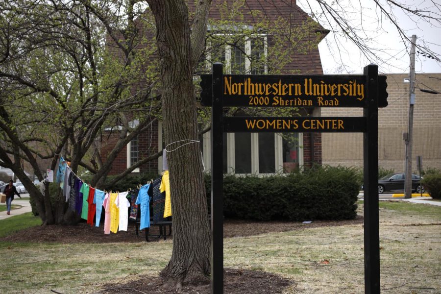 Photo of a black sign in front of a building reading “Northwestern University Women’s Center.”