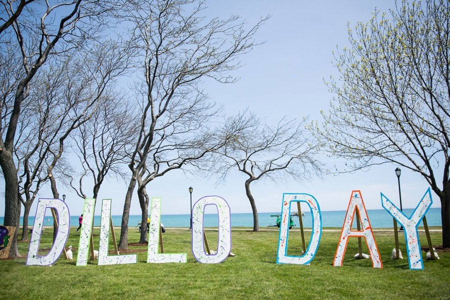 Large painted letters spell out “Dillo Day” on the lakefill.