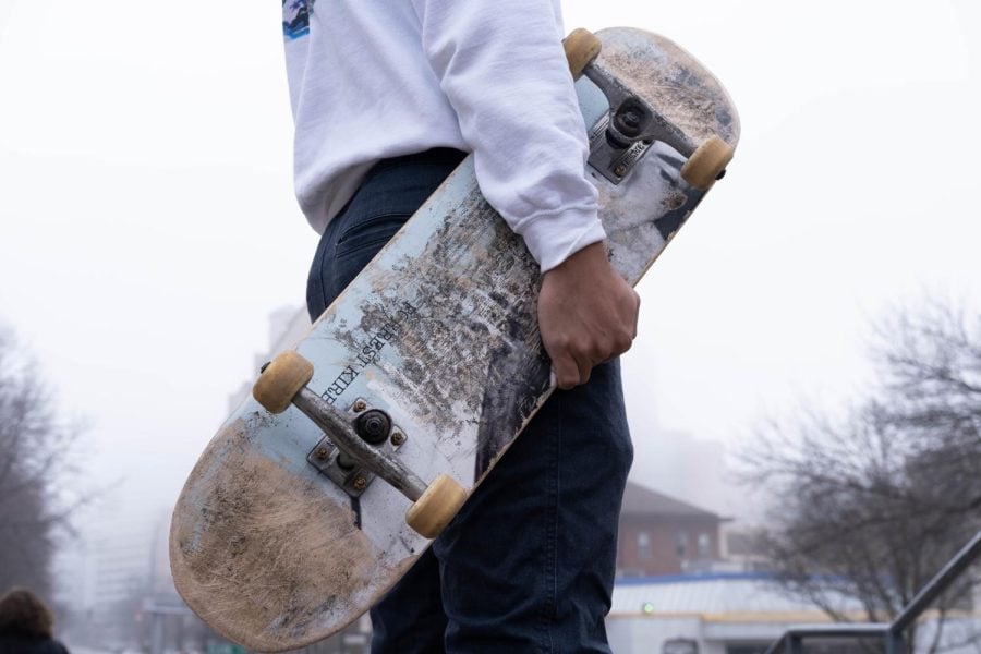 A+skater+holds+a+skateboard.