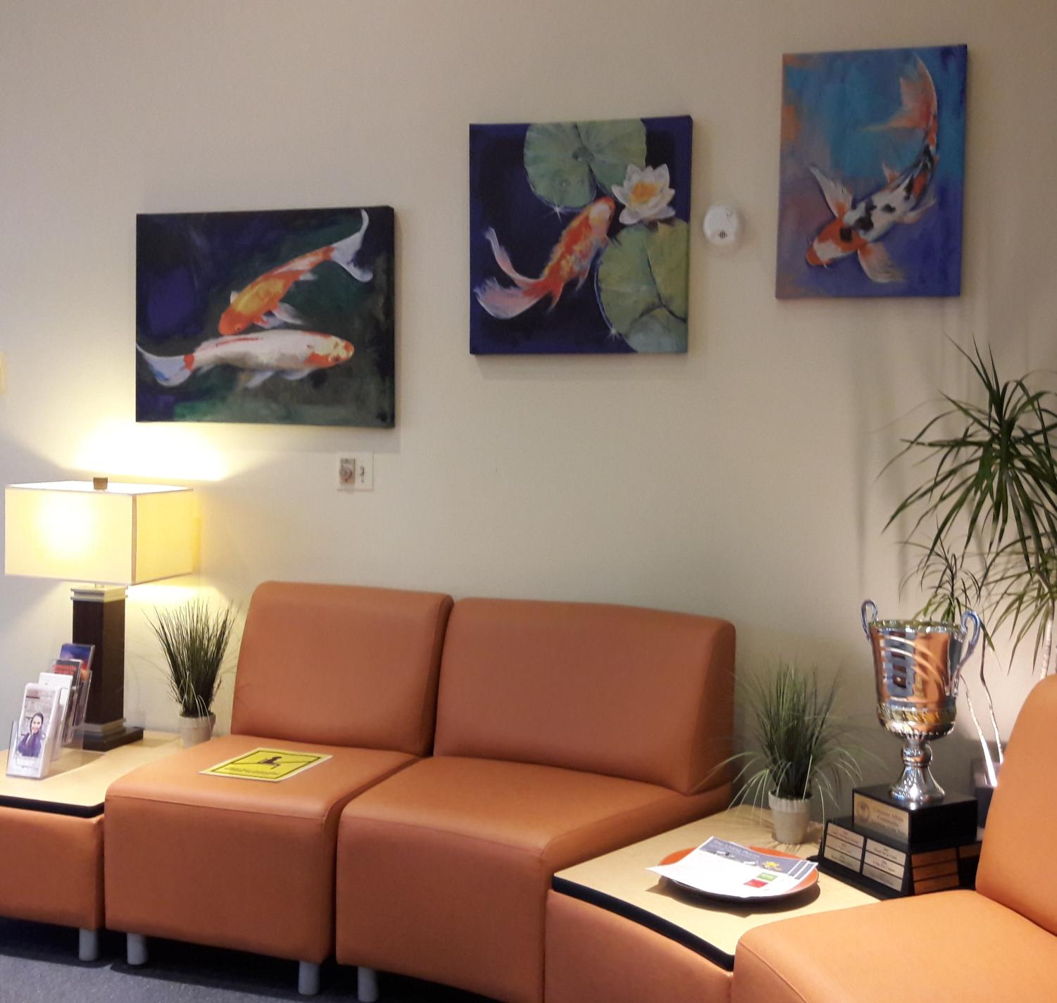  Orange couches, plants, a trophy and three koi fish paintings in the Living Room at Turning Point.