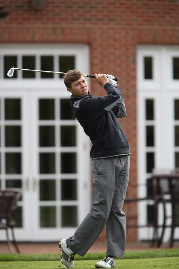 A+golfer+swings+at+a+ball+on+a+tee.