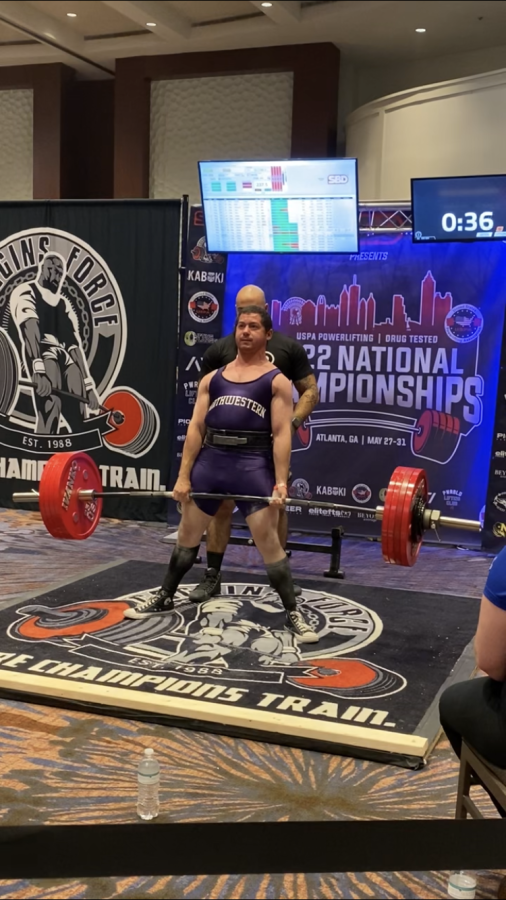 Wearing the Northwestern singlet, postdoctoral research associate Joshua Tropp competes in the deadlift event at the United States Powerlifting Association’s Drug Tested 2022 National Championships.
