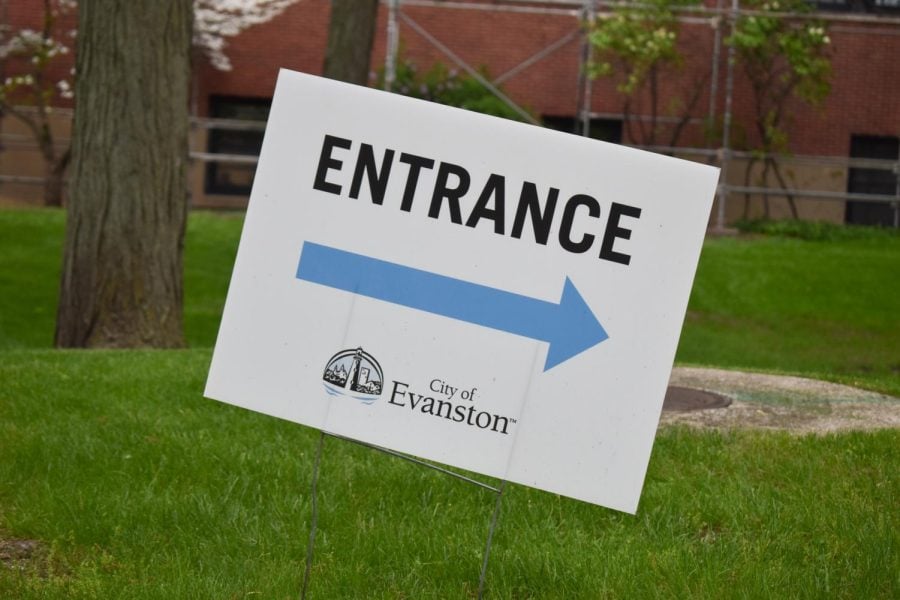 A white sign with black text that reads “Entrance” with the “City of Evanston” logo and an arrow pointing rightward.