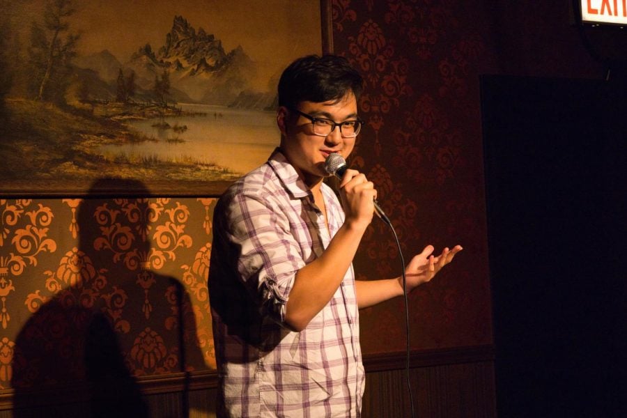 A man performs stand-up comedy into a microphone.