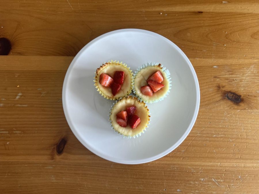 Three strawberry mini cheesecakes in a bowl.