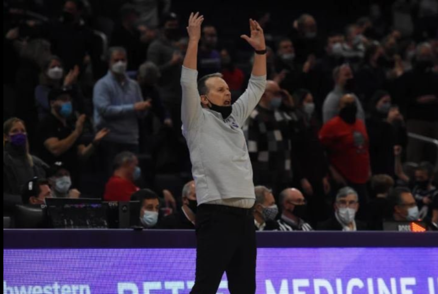 A man wearing a gray sweatshirt throws his hands in the air.