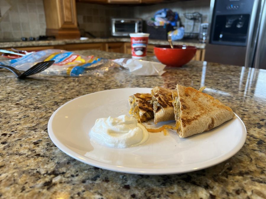 Quesadillas plated with sour cream.