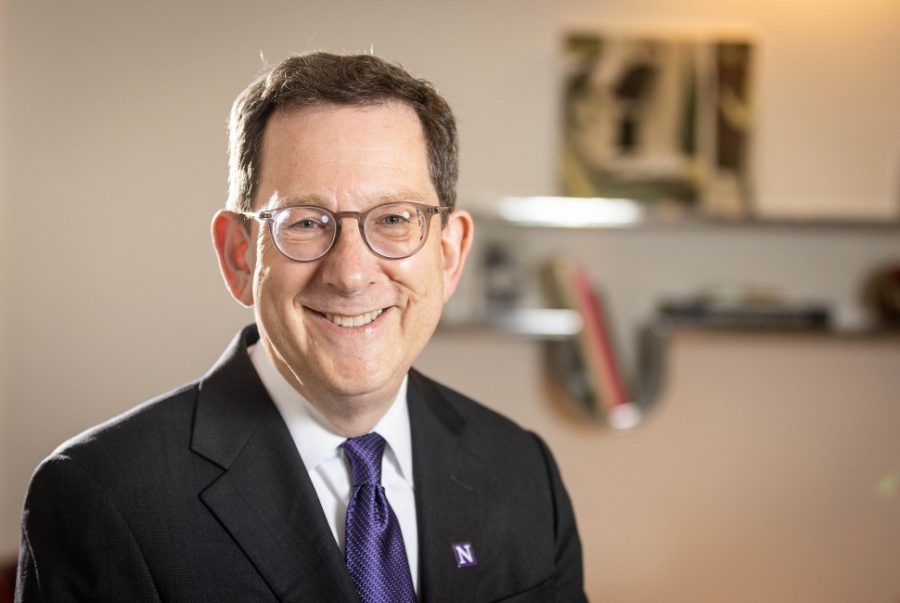Michael Schill wears a suit with a purple tie and a Northwestern pin.