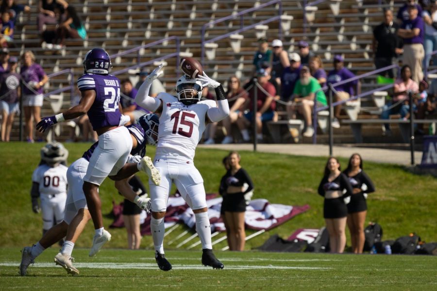 Player in white jersey attempts to catch a football.