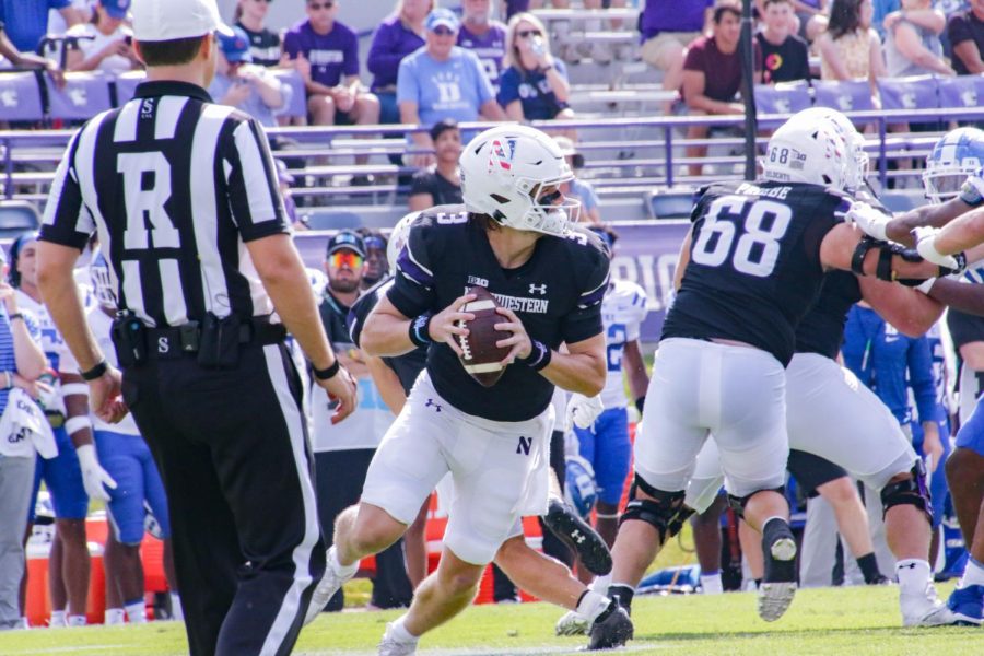 Player in black jersey looks for a downfield pass