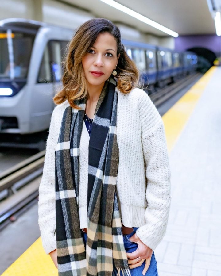 Photograph of woman wearing scarf in train station.