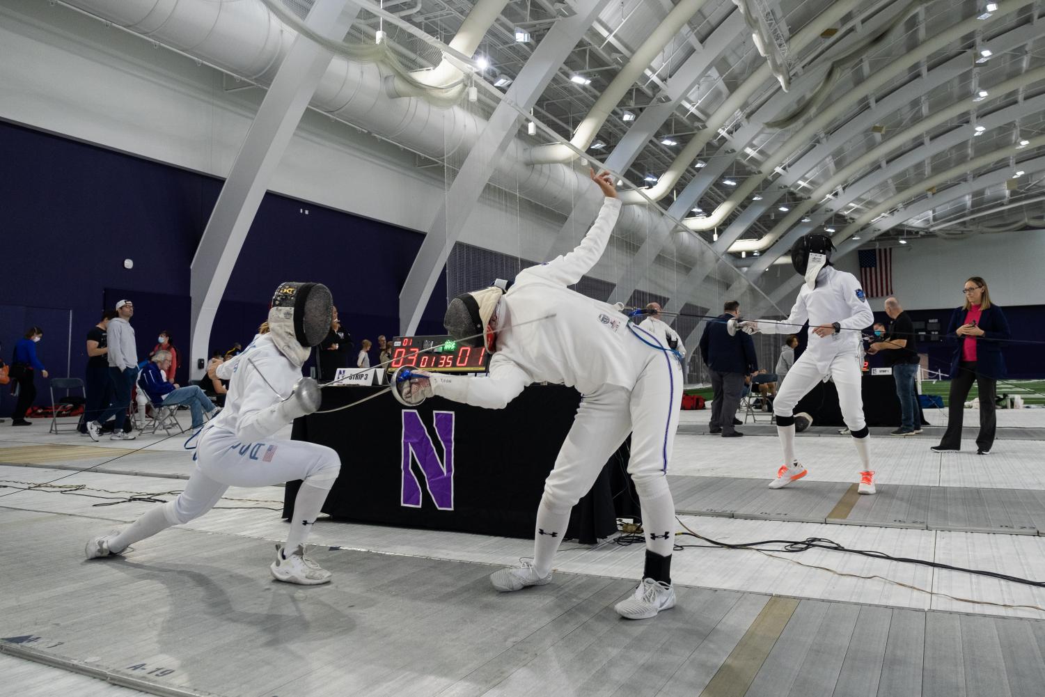 Two fencers hit each other with weapons, one bending over.