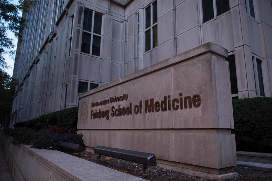 Sign in front of tan building that says “Northwestern University Feinberg School of Medicine”