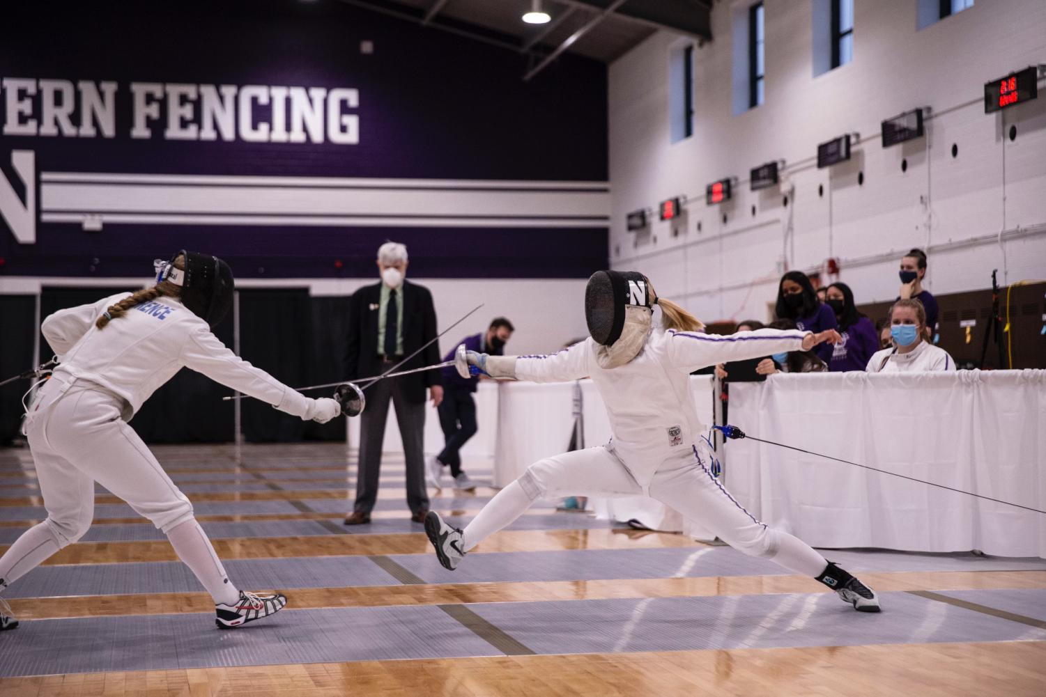 A+fencer+wearing+white+and+purple+gear+battles+in+an+epee+bout.