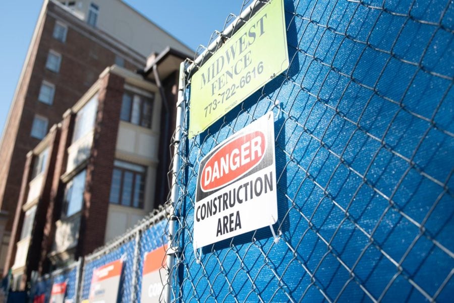 A “Danger: Construction area” sign on a chain-link fence outside of the empty Burger King building in downtown Evanston.