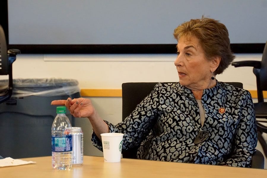 Jan Schakowsky poses in forum, points to left.