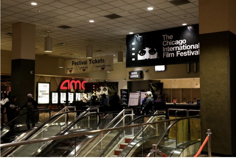 Chicago International Film Festival banners hang from the ceiling near escalators in a theater lobby.