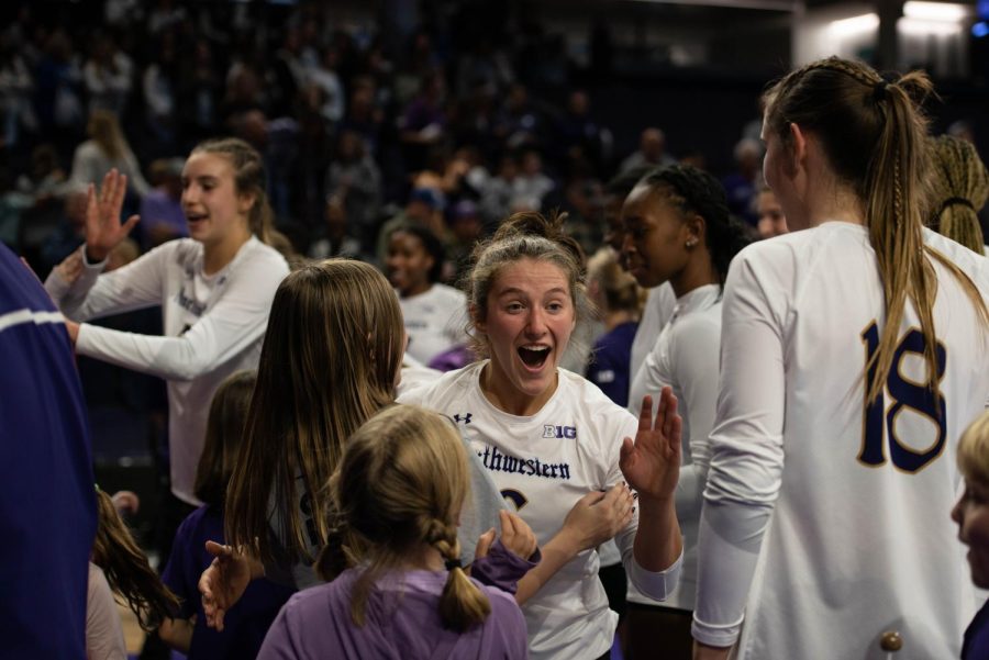 Sophomore defensive specialist and libero Ellee Stinson greets kids after the Wildcats’ win against Rutgers.  