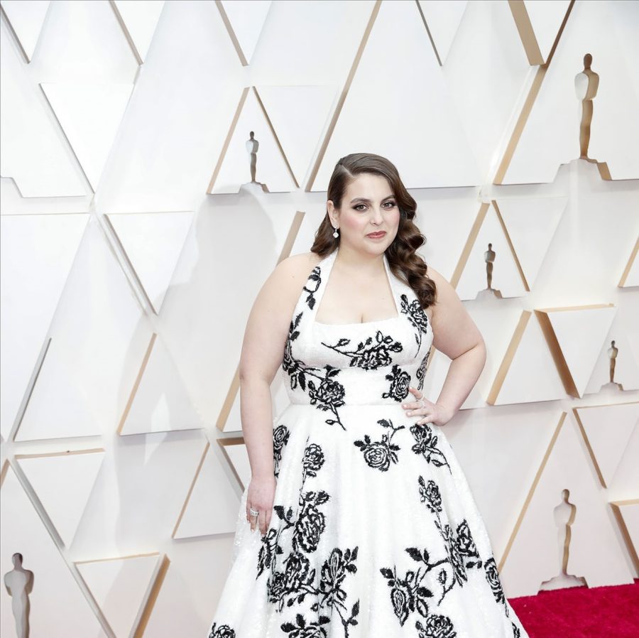 Beanie+Feldstein+stands+on+a+red+carpet+in+a+white+dress+patterned+with+navy+flowers.