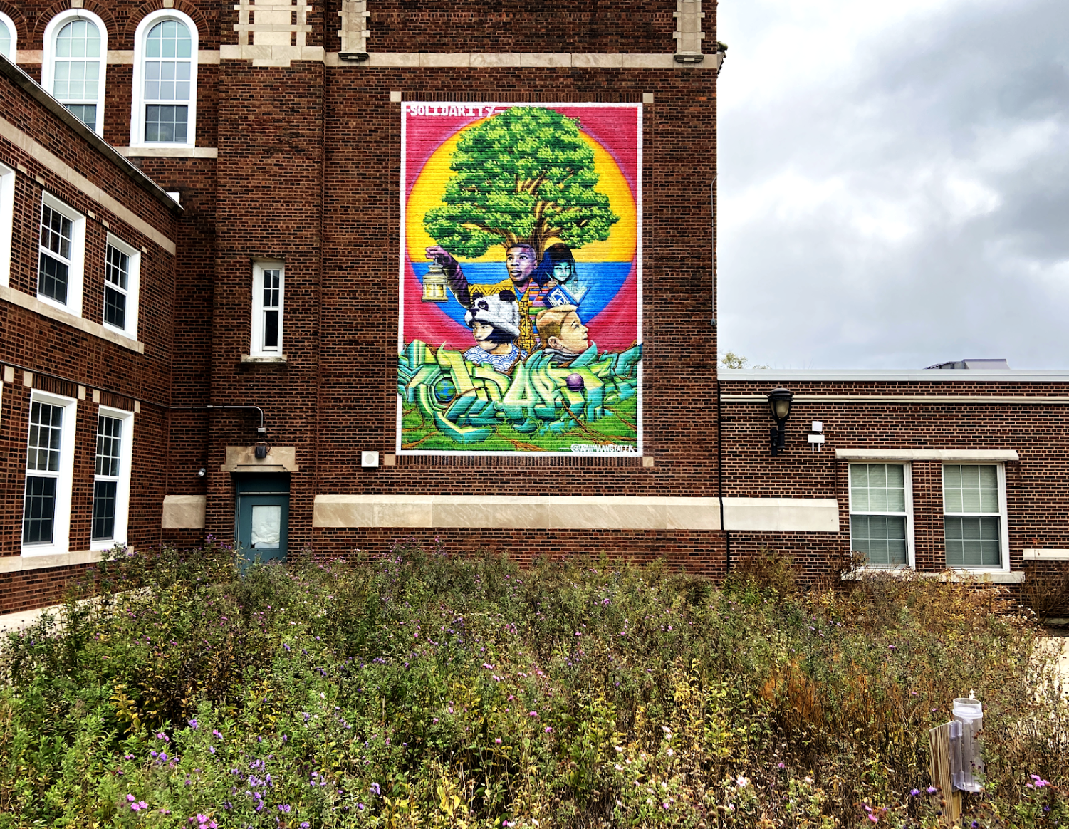 A mural appears on the side of a brick building.