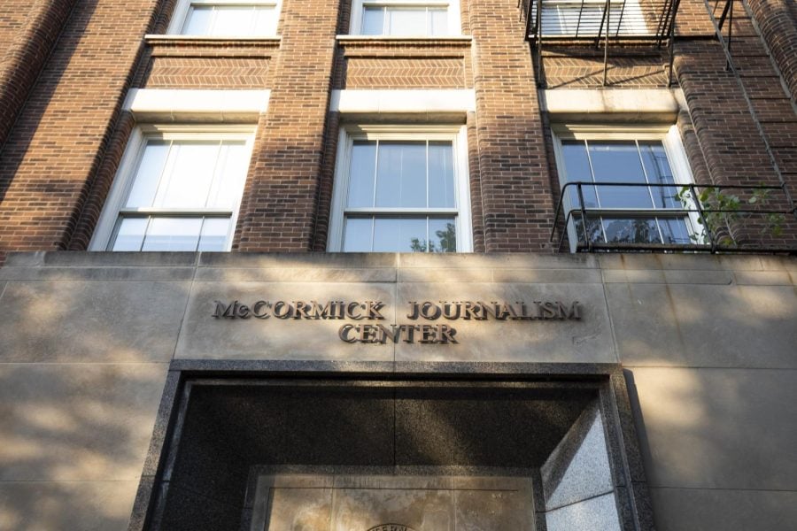 Fisk Hall pictured. A sign reading “McCormick Journalism Center” is set above a door and below a series of windows on a brick wall.