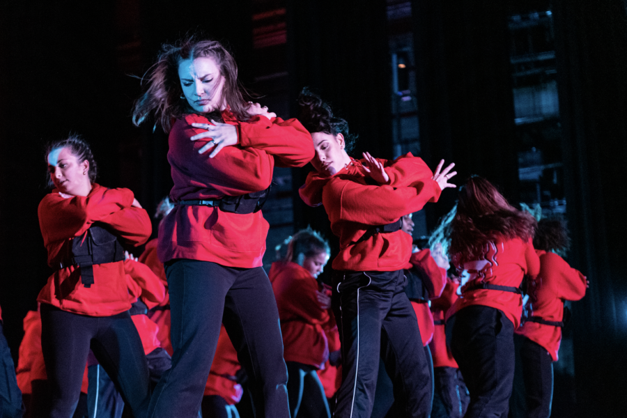 Dancers dressed in red dance on the stage.