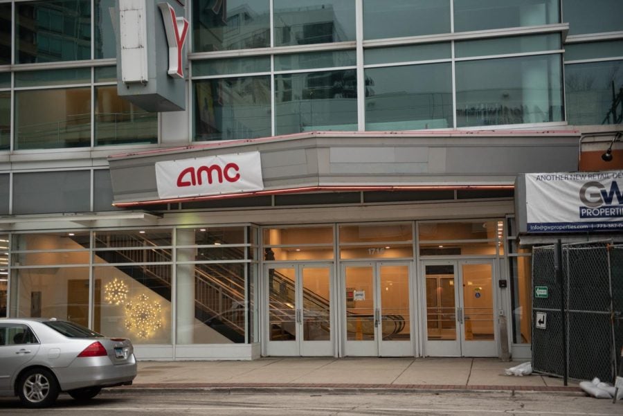 A silver building with a glass wall and a sign that reads “Century” and a smaller sign below it that reads “AMC.”