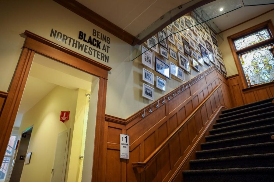 A staircase next to a doorframe with a sign saying “Being Black at Northwestern.”