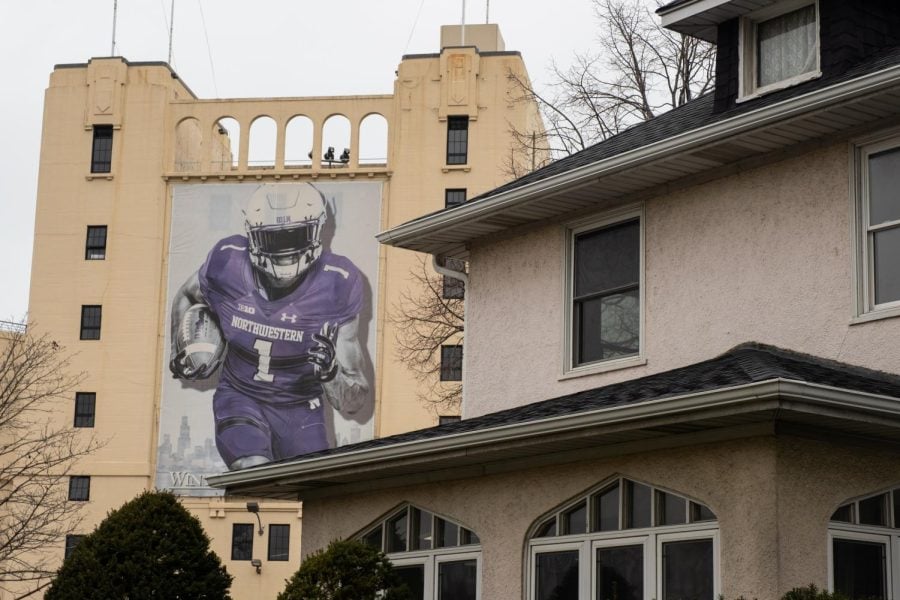 An image of a football player wearing purple hangs on the side of a tan building.
