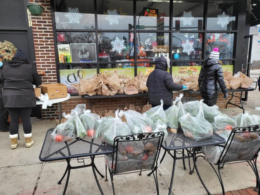 Two rows of tables filled with groceries are set up in front of C&W Market.