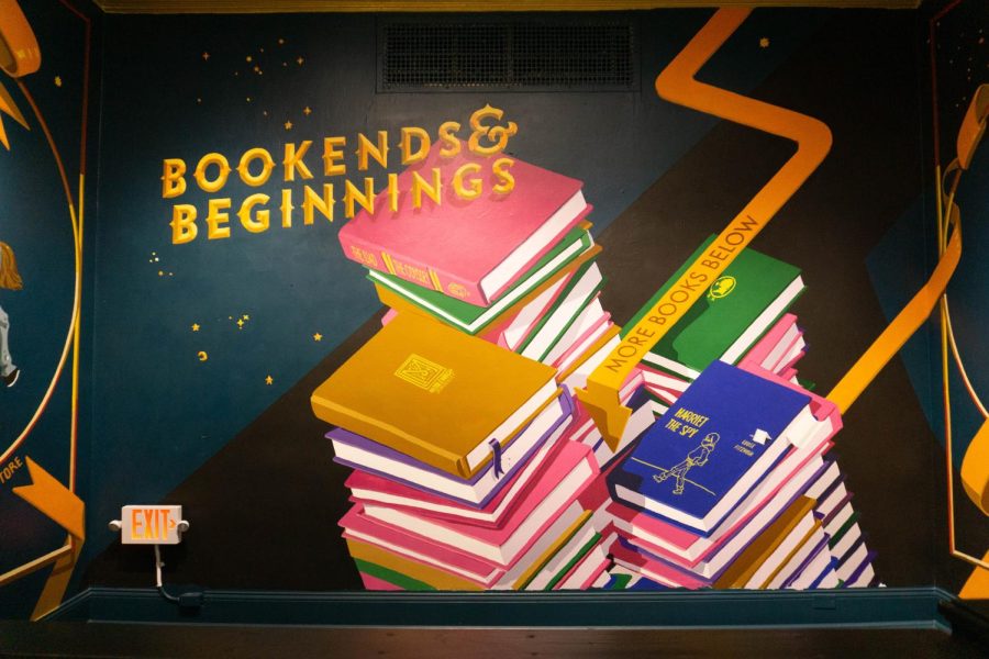 A mural of books with gold lettering that reads “Bookends & Beginnings.”