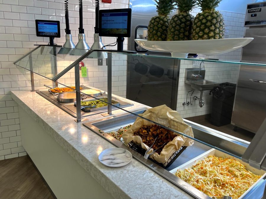 A food bar including foods such as chips and green beans. Displays on top show names of foods without calorie counts.