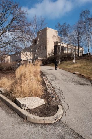 A concrete path leads up a steep hill to a large building.