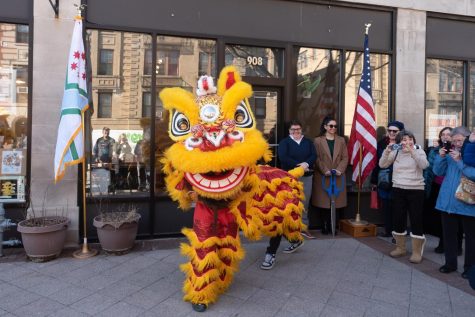 A yellow and red lion dancer in front of a building 